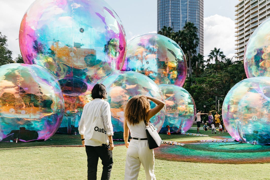 two people in front of giant bubble like structures